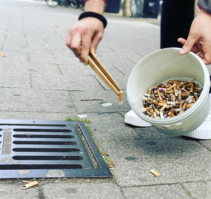 Peuken in emmer, opgeraapt met houten tang