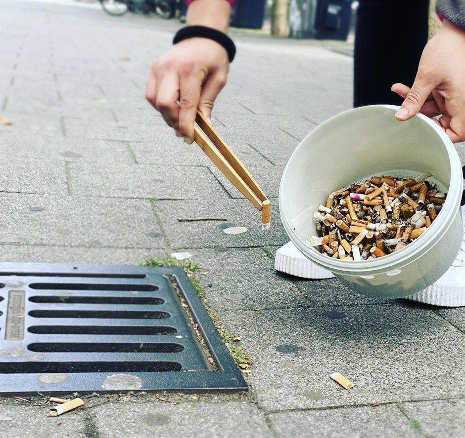 Peuken in emmer, opgeraapt met houten tang