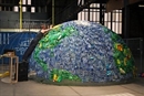AJ Smith voegt lege plastic flessen toe aan een halve globe van flessen