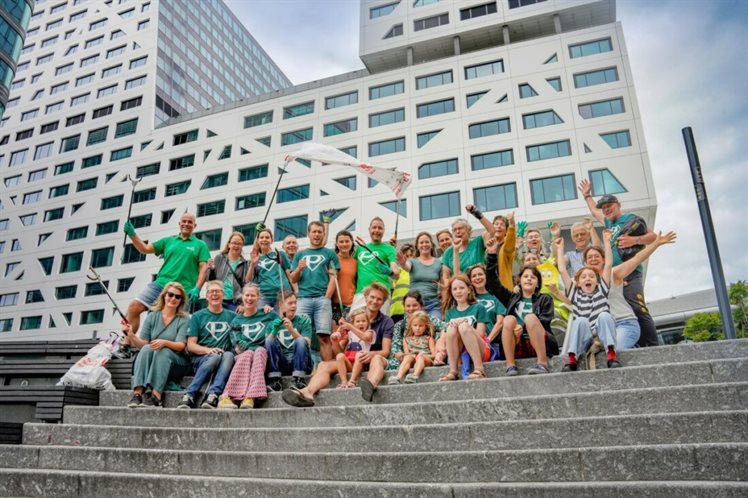 Vrolijke groepsfoto met grijpers op de trap voor het nieuwe gemeentehuis van Utrecht.