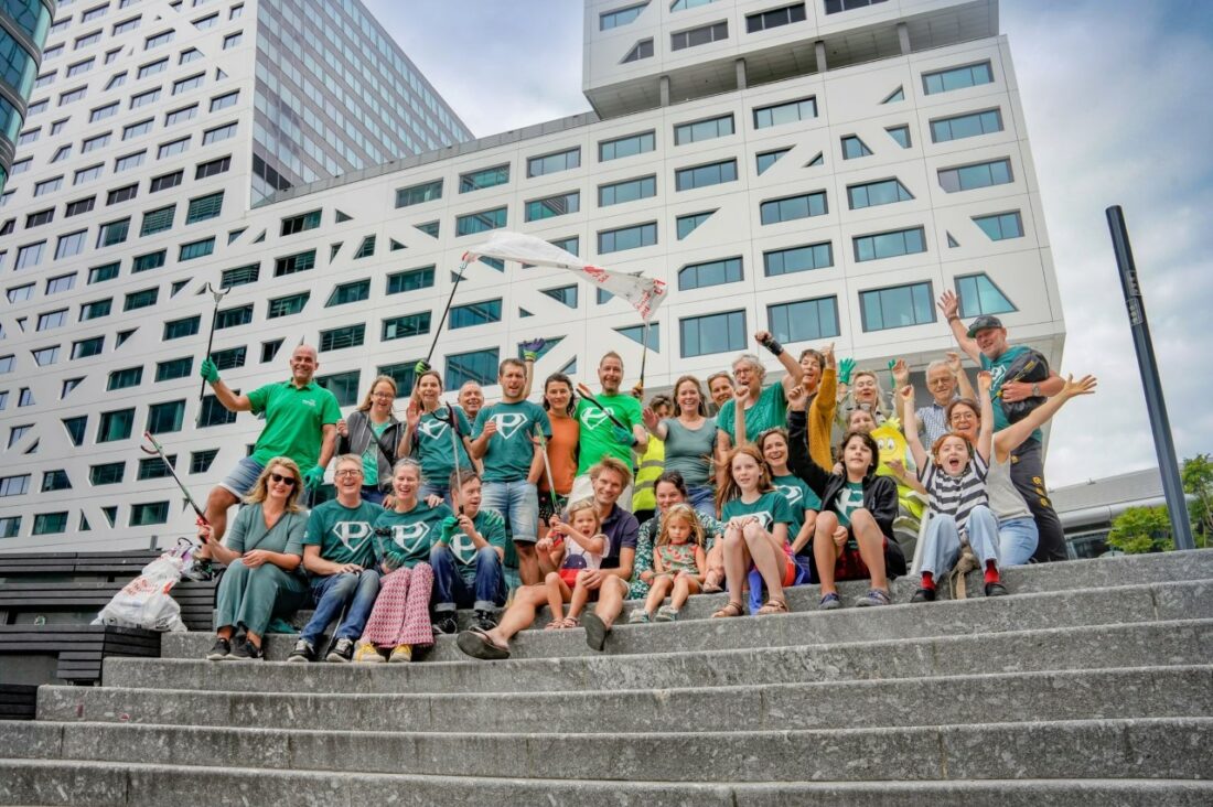 Vrolijke groepsfoto met grijpers op de trap voor het nieuwe gemeentehuis van Utrecht.